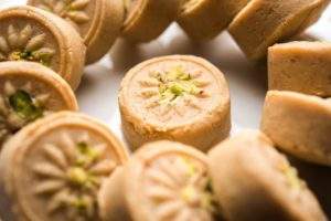 brown pera pedha is indian sweet made using khoa sugar traditional flavorings including cardamom seeds pistachio nuts served bowl plate selective focus 466689 58311