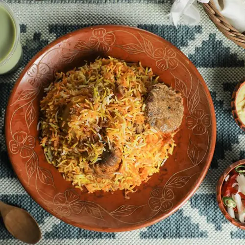mutton-kacchi-biryani-with-salad-borhani-chui-pitha-served-dish-isolated-mat-top-view-indian-bangladeshi-food_689047-4948